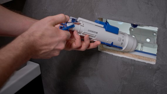 Muškarac ugrađuje Geberit ventil za ispiranje u ugradbeni vodokotlić (© Ben Huggler)