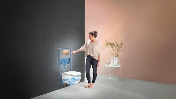 Žena aktivira ispiranje Geberit WC sustava. (© Geberit)